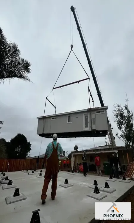 Crane lifting and installing new manufactured home on prepared foundation in Mesa, Arizona