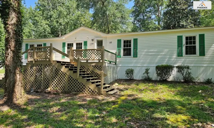 Selling Double wide mobile home with new white vinyl skirting and front porch deck, providing enhanced curb appeal and underbelly protection in Phoenix, AZ.